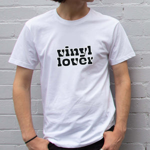 I'm With The Band® Vinyl Lover T-shirt with bright multi-colour print on white T being worn by a faceless man standing against a white painted brick wall
